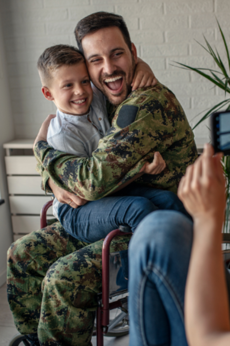 Disabled American Veteran, embracing his son, supported by Patriot Clean Out's donations to DAV.org