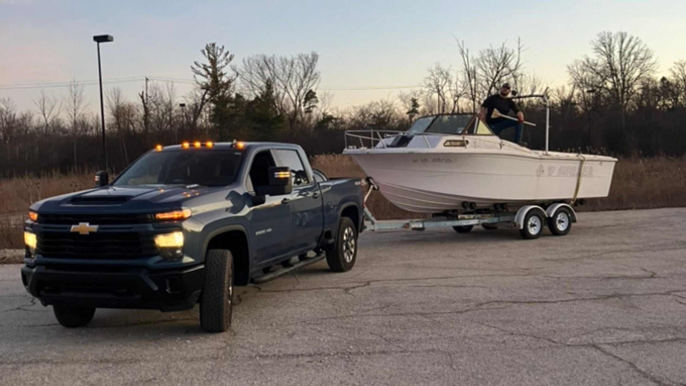 Patriot Clean Out truck hauling an old boat in Valparaiso, IN as part of their licensed boat removal and junk boat hauling service in Northwest Indiana.