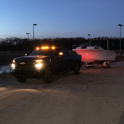 Boat junk removal at night by Patriot Clean Out, hauling away storm-damaged boat from a parking lot in Northwest Indiana.