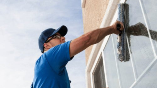 A Patriot Clean Out employee professionally cleaning a client's windows in Valparaiso, Indiana. 